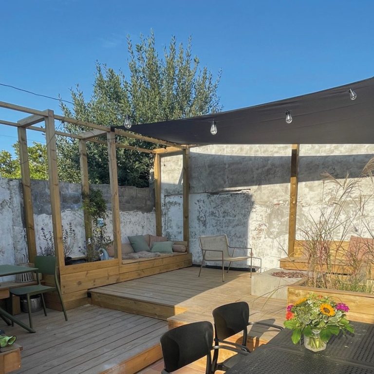 Seitenasicht auf romantisches Tiny House Einstein mit rosa Fahrrad und weiten Blick in die Polderlandschaft